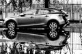 modern car side view in black and white. reflection in water puddle after heavy storm Royalty Free Stock Photo