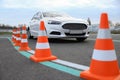 Modern car on test track with traffic cones, low angle view. Driving school Royalty Free Stock Photo