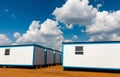 Modern caravans in a field under a blue cloudy sky and sunlight