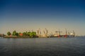 Modern cargo port with many container cranes in Hamburg harbor during warm sunset, Germany