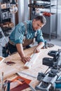 Modern carpenter measuring wooden plank