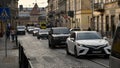 Modern cars driving by old Lviv city street with busy traffic