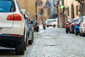 Modern cars parked on city street side in residential discrict. Shiny vehicles parked by the curb. Urban transportation