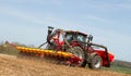Modern case tractor drilling seed in field