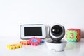 Modern CCTV security camera, monitor and child puzzle on table against white background.