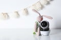 Modern CCTV security camera, toy bunny near wall with nursery garland. Royalty Free Stock Photo