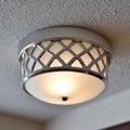 Modern ceiling light with metal grid design on textured ceiling. Royalty Free Stock Photo