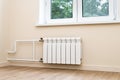 Modern water heating radiator attached to the wall under the window Royalty Free Stock Photo