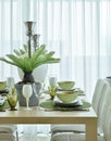 Modern ceramic tableware in green color scheme setting on dining table