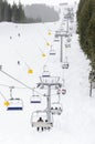 Modern chair ski lift in ski resort and people skiing in the background