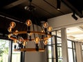Modern chandelier in living room near glass window, loft style, vintage ceiling light or light bulbs hanging from wooden ceiling. Royalty Free Stock Photo