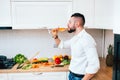 Modern chef preparing salad for dinner and drinking wine. Close up details of elegant man cooking