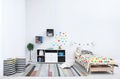 Modern child room interior with comfortable bed and striped carpet. Royalty Free Stock Photo