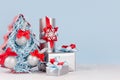 Modern christmas background in light pastel blue and silver color - decorative fir tree with balls and various gift boxes with red Royalty Free Stock Photo