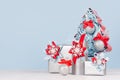 Modern christmas background in light pastel blue and silver color - decorative fir tree with balls and various gift boxes with red Royalty Free Stock Photo