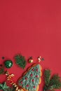 Modern christmas flat lay. Stylish christmas tree cookie, baubles, fir branches, confetti on red background. Seasons greeting card Royalty Free Stock Photo