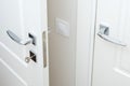 Modern chrome door handle and lock with key. White interior door