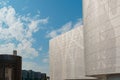 Modern city buildings with metal mesh wall and blue sky