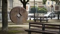 Modern city park with benches and metal round statue with a diamond-shaped hole in the middle of it. Stock footage. A