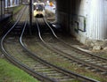 A modern city tram passes under a railway bridge in the old district of the city Royalty Free Stock Photo