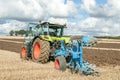 Modern claas tractor pulling a plough