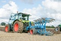 Modern claas tractor pulling a plough