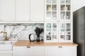 Modern classic kitchen interior with kitchen appliances and white ceramic sink with gold mirror faucet on wood top with marble Royalty Free Stock Photo