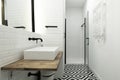 Modern cloakroom with a black and white tiled floor, a white porcelain