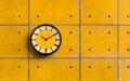 Modern clock on textured yellow wall creating minimalist industrial design composition with copy space Royalty Free Stock Photo