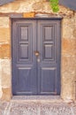 Modern closed dark wooden door on yellow cement textured house Royalty Free Stock Photo