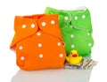 Modern cloth diapers, money, and rubber duck isolated on white.