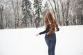 Modern clothes. Rear view of girl with long hair runs near the forest to the automobile in wintertime Royalty Free Stock Photo