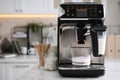 Modern coffee machine making tasty drink in office kitchen, space for text