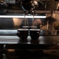 Modern coffee machine pours hot espresso into vintage black cups in a coffee shop. Great morning drink. Close-up cafe shop details Royalty Free Stock Photo