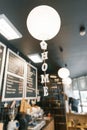 Modern coffee shop, interior, bar counter, focus on white round paper lamp and the word home in wooden letters. Home cafe concept Royalty Free Stock Photo