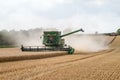 Modern combine harvester cutting crops corn wheat barley working golden field Royalty Free Stock Photo