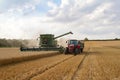 modern combine harvester cutting crops corn wheat barley working golden field Royalty Free Stock Photo