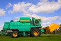 Modern combine harvester on green lawn with fresh grass