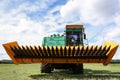 Modern combine harvester on green lawn with fresh grass