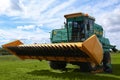 Modern combine harvester on green lawn with fresh grass