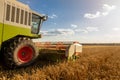 modern combine (harvester) harvesting on wheat field, cloudy sky Royalty Free Stock Photo