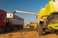 Modern combine harvester unloading grain in truck