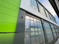 Modern commercial building, office or shopping center with large windows, light green. Without signs or inscriptions. Shot with a Royalty Free Stock Photo