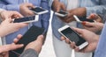 Closeup of diverse people standing in circle holding smartphones