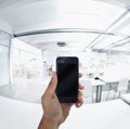 Modern communication. POV shot of a person using a cellphone in a modern office. Royalty Free Stock Photo