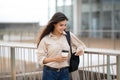 Modern communication for study. Happy young asian lady student with backpack, cup of coffee takeaway Royalty Free Stock Photo