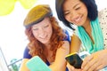 Modern communication. Two teenage girls sitting outside texting on their cellphones. Royalty Free Stock Photo