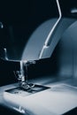 Modern compact electric sewing machine in the evening. View of needle and thread. Illumination from the built-in incandescent lamp Royalty Free Stock Photo