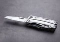 Modern compact portable multitool on grey table Royalty Free Stock Photo