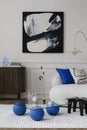 Modern composition of living room interior with mock up poster frame, wooden sideboard, glass coffee table, stylish sofa, blue Royalty Free Stock Photo